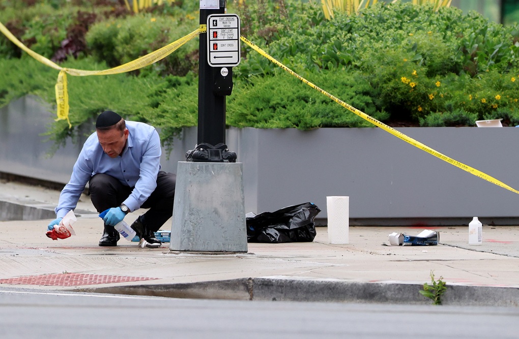 Rabbi Mark Rosenberg, director of the Jewish burial society Chesed Shel Emes and law enforcement chief chaplain of Florida, cleans blood off the sidewalk at the shooting location outside of the Capital Jewish Museum on May 22, 2025, in Washington, DC