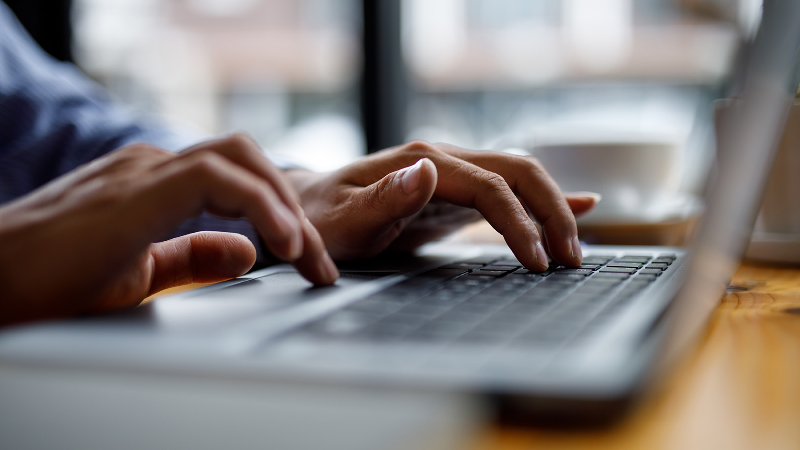 Hands typing on laptop