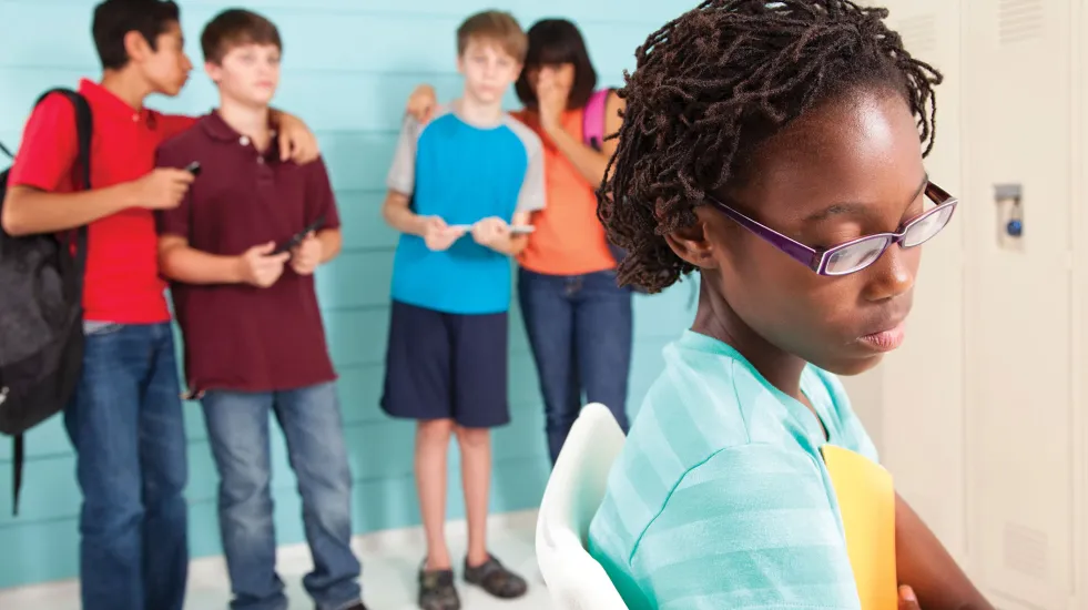 Preteen students using technology to cyber bully an African American female classmate