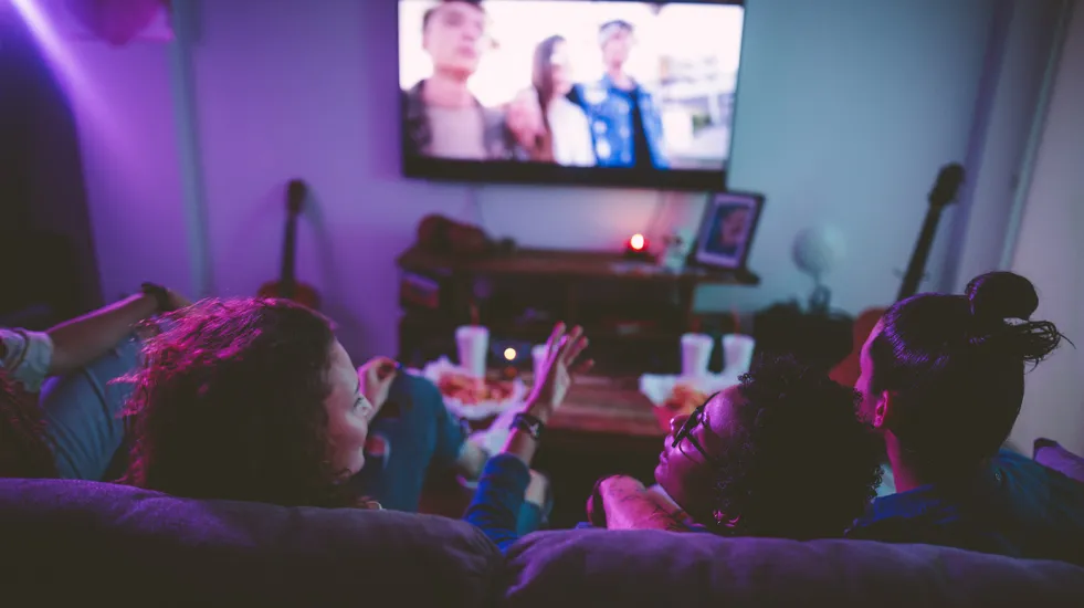 Teens watching TV together
