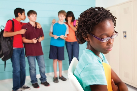 Preteen students using technology to cyber bully an African American female classmate