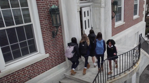 Students walking in and out of a school's front door