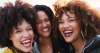 Three ethnic females with natural hair styles laughing together